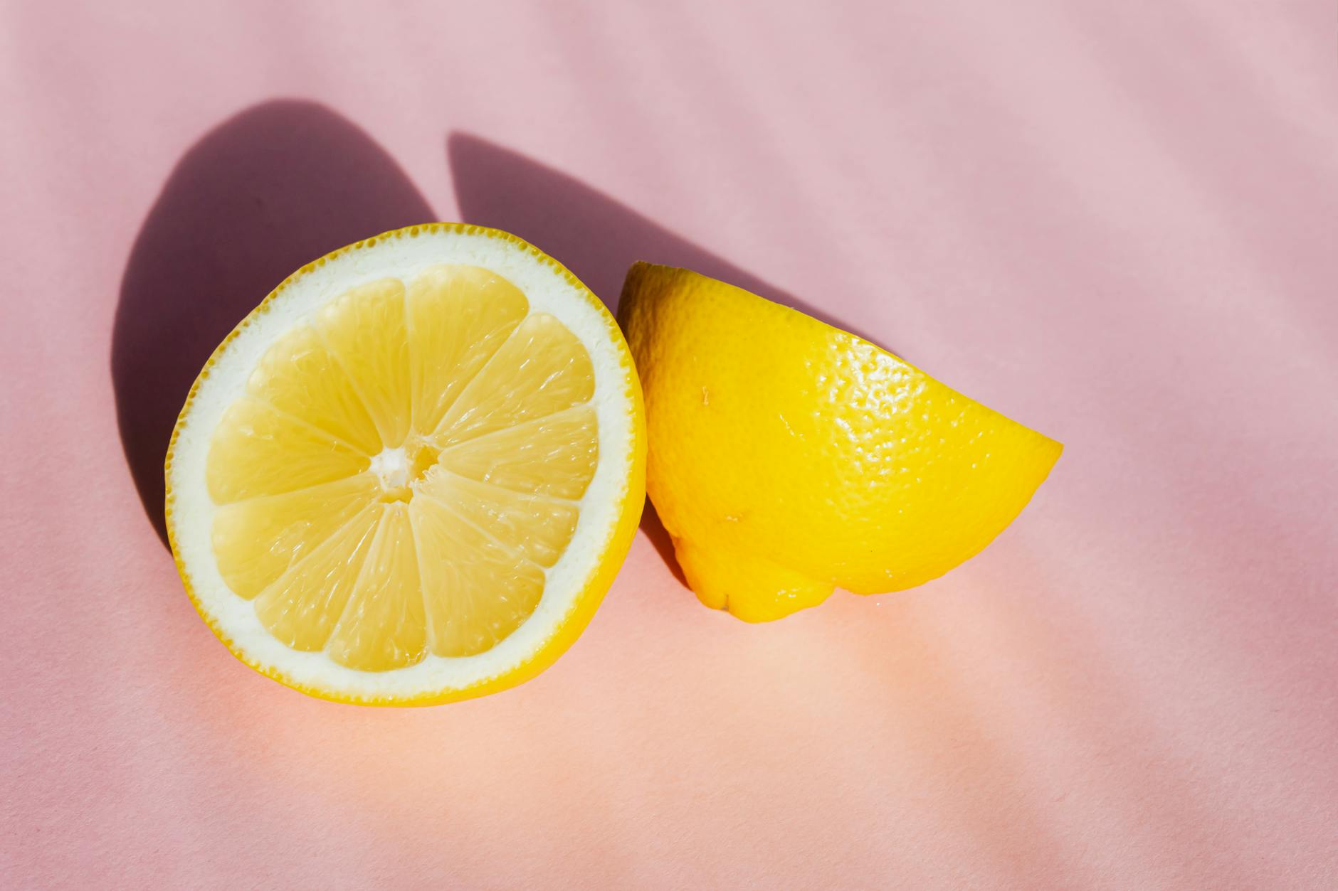 Fresh lemon halves on a pink background, symbolizing renewal and reconnection with sensation
