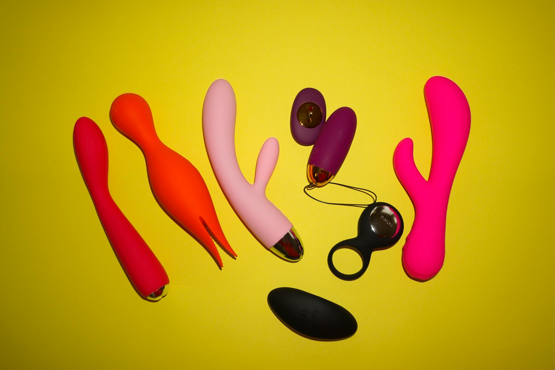A hand holding a blue silicone vibrator against a solid purple background, representing self-care and intimacy.